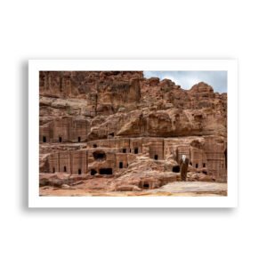 Man stands before rock-cut tombs in Petra, Jordan