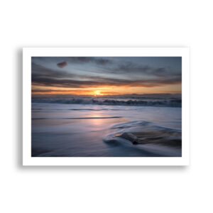 Ocean waves crash over ice on a black Icelandic beach