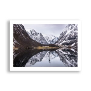 Snowy Norwegian mountains reflected in calm water